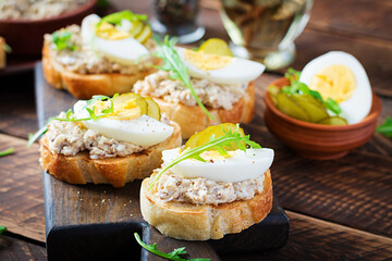 Toasted bread with a salted codfish mousse on wooden cutting board. Mackerel paste on toasts from...