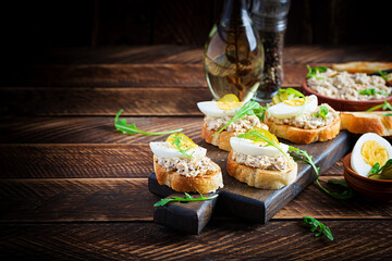 Toasted bread with a salted codfish mousse on wooden cutting board. Mackerel paste on toasts from fried bread.  Scandinavian cuisine