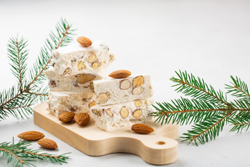 Torrone - soft italian nougat with almonds. Winter decoration. White background.
