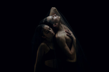 Touch. Graceful classic ballet dancers isolated on black studio background. Couple in minimalistic...