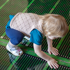 Little girl installs infrared radiant heat film for floor heating.