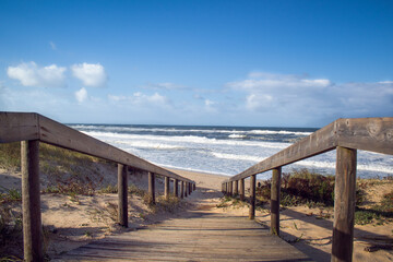 Fototapeta na wymiar Beach wooden boardwalk leading down to the Atlantic Ocean. Landscape photography at Quiaios Beach in Portugal