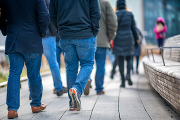 Naklejka premium Walking along High Line in Manhattan, New York City. Detail on moving people legs