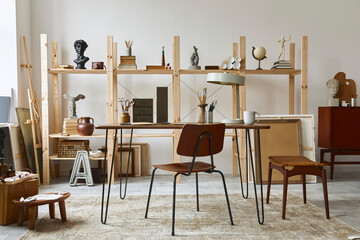 Unique artist workspace interior with stylish desk, wooden easel, bookcase, artworks, painting accessories, decoration and elegant personal stuff. Modern work room for artist. Template.