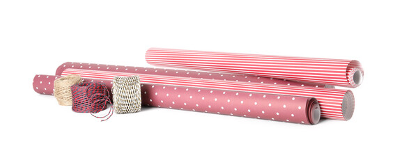 Different colorful wrapping paper rolls and ropes on white background