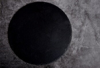 Fototapeta na wymiar Empty black rustic slate stone plate on dark concrete background, copy space, top view