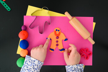 Making the gingerbread man with modelling clay (salt dough) and tools