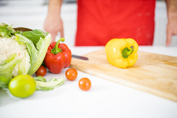 Bag of vegetables above a white table and a cutting board