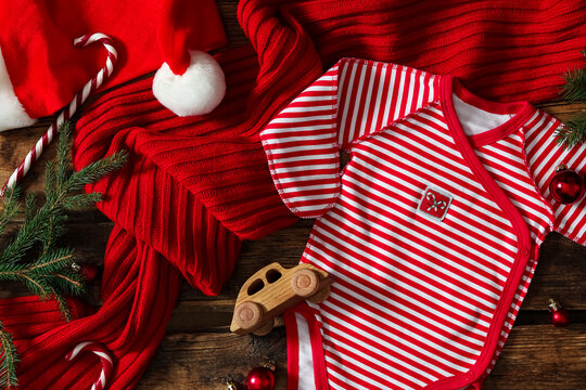 Flat lay composition with Christmas baby clothes on wooden background
