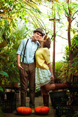 Romantic picture of lovely couple on a date in casual clothes, in beautiful glass greenhouse. Happy man and woman hugging and holding hands, spending time together. Valentine's Day.