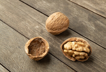 Walnuts and open nut over a wooden table
