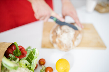 Obraz na płótnie Canvas Male hands slicing bread on a cutting board
