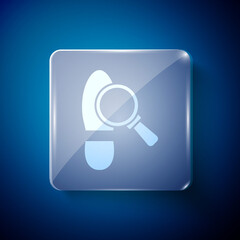 White Magnifying glass with footsteps icon isolated on blue background. Detective is investigating. To follow in the footsteps. Square glass panels. Vector.