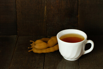 tamarind juice and tamarind fruit on wooden background copy space