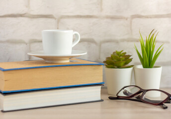 A small Cup of morning coffee and a book on the table.