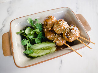 Toasted meatballs topped with spicy sauce