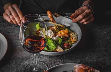 woman eating healthy salad from bowl sitting in cafe