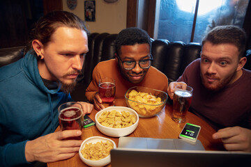 Waiting. Excited fans in bar with beer and mobile app for betting, score on their devices. Screen with match results, emotional friends cheering. Gambling, sport, finance, modern techn concept.