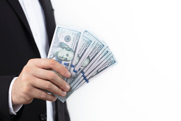 A hand of a businessman holding stack of hundred dollar bills, isolated on white background.