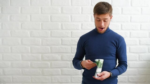 A man counts the money with a satisfied face in a pack of Euro banknotes with a face value of one hundred euros