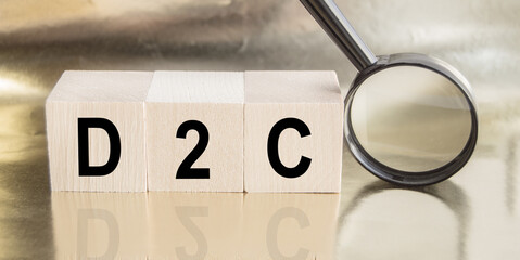 D2C word on wooden cubes, next to a magnifying glass, business concept of a startup and direct sales