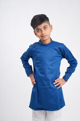 Cute indian little boy in ethnic wear and showing expression over white background