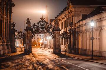 An empty archway at night above a street. The scenery is illuminated by yellow street lamps.