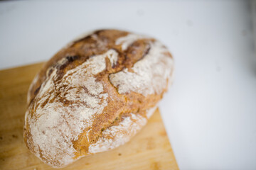 Bread on a cutting board above a white table