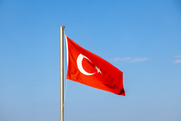 Turkish flag waving in the wind. Photo of the Turk national landmark on a flag pole.