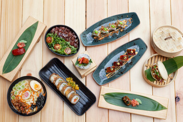 Varios platos diferentes de sushi sobre mesa de madera y fotografía tomada en picado