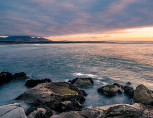 Sunset at Ritoque beach on a cloudy day with a mountain at behind