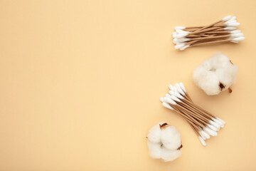 Cotton ear swabes with flower on beige background