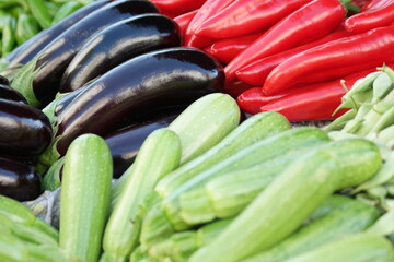 Freshly picked vegetables at street market. Zucchini, eggplants and red bell peppers. Healthy food concept.