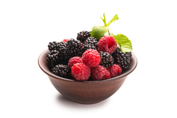 Raspberry, blackberry and mint leaf in ceramic brown bowl isolated on white