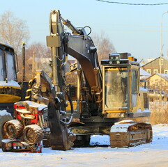 Forestry machinery arvestr against the backdrop of a rustic winter landscape on a clear frosty day