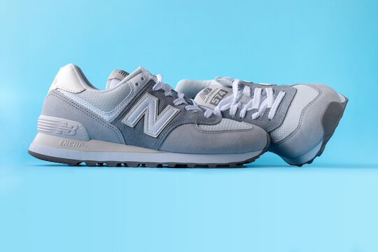 New Balance 574 light gray sneakers on blue background. Suede and mesh  walking, casual sport shoes closeup. Illustrative editorial photo Stock  Photo | Adobe Stock