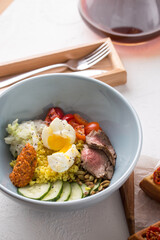 nutrient bowl for healthy breakfast with egg, beef, tomato, cucumber on the table