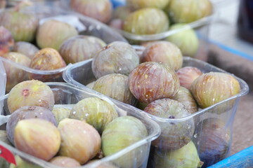 Boxes with fresh figs at street market. Ripe figs in a row for sale at fruits market.