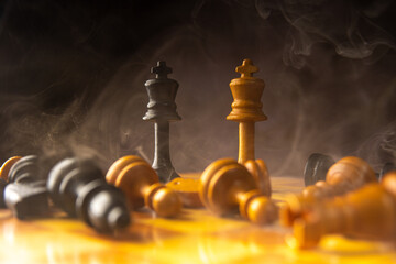 Chess pieces on the board with smoke, low key images, shallow depth of field, selective focus.