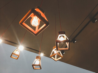 Decorative fixture, light bulb and lamp in modern style hanging from the ceiling on white background. Vintage design.