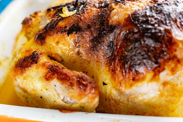 Hot baked chicken with a delicious brown fried crust. Cooked fried poultry, watering with its own juice and fat. Rich orange color of meat.