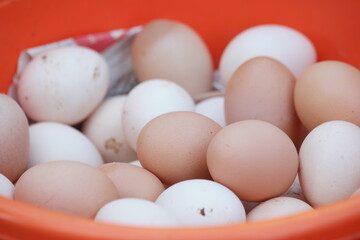 Fresh hen eggs at the market stall. Pile of organic farm eggs close up. Healthy eating concept.