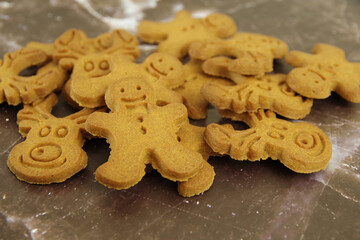 Bunch of different shaped Christmas cookies on a brown background. Closeup