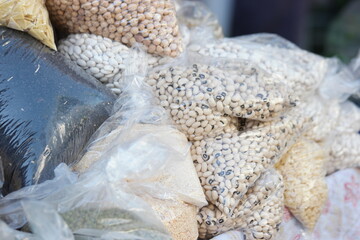 Display of organic produce at farmers market. Close up various groats in transparent plastic bags.