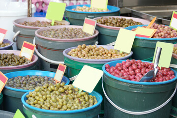 Different types of olives on display at market. Assortment of olives at market place.