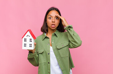 young hispanic woman looking happy, astonished and surprised, smiling and realizing amazing and...