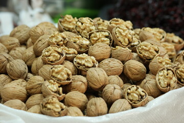Close up of walnuts at farmers market stall. Farmers market walnuts in shell for sale. Food industry.