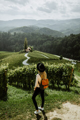 Young girl in hat stands in background of famous road in shape of heart. Vineyard Spicnik near town...