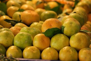 Pile of ripe mandarins for sale at market. Organic fruits background. Food production industry.