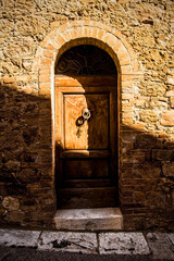 A door in an empty disused building in the historic medieval village of San Quirico D'Orcia, Siena Province, Tuscany, Italy
